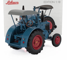Modelo a escala 1:18 de tractor vintage azul de Schuco con ruedas rojas, disponible en Vroomi.