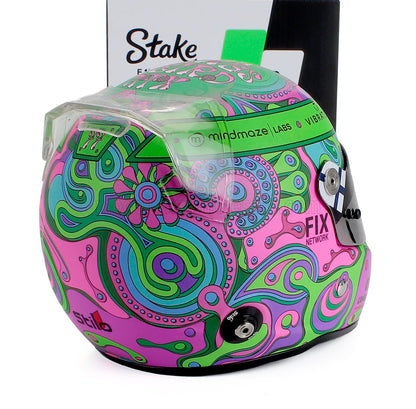 Casco de carreras psicodélico y colorido con motivos verdes, rosas y azules, actualmente disponible en línea.