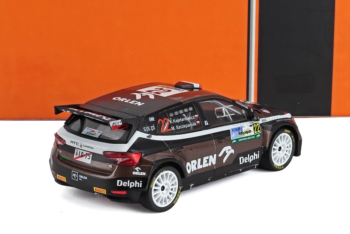 Diecast model of a black and brown rally car with white wheels, Orlen and Delphi logos, seen from rear side, available on Vroomi