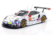 Modelo de coche de carreras Porsche 911 GT3 R blanco con llantas doradas y detalles en azul y rojo, disponible en Vroomi.