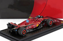 Coche a escala de Fórmula 1 rojo con logotipos de patrocinadores, expuesto en un soporte, actualmente a la venta en Vroomi.