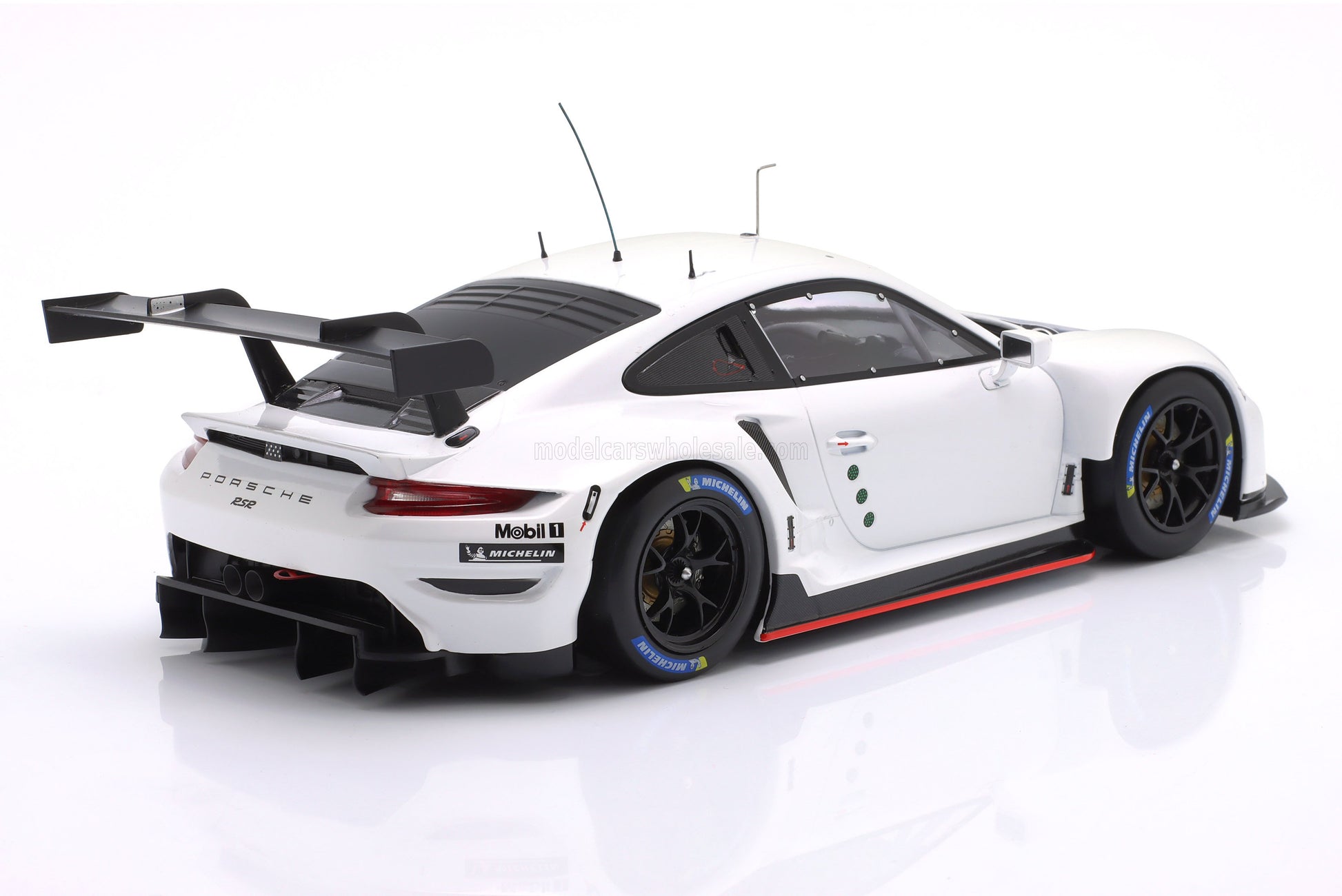 Modelo a escala del coche de carreras Porsche GT blanco con alerón trasero ancho, disponible para coleccionistas en Vroomi.