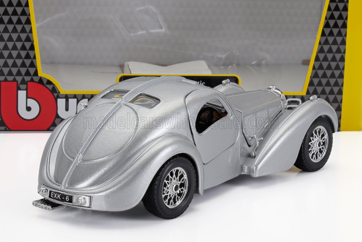 Modelo clásico de coche plateado con ruedas detalladas y matrícula trasera EXK-6, ofrecido a través de Vroomi.