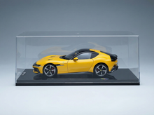 Maqueta amarilla de un coche deportivo en vitrina, réplica coleccionable disponible bajo pedido.