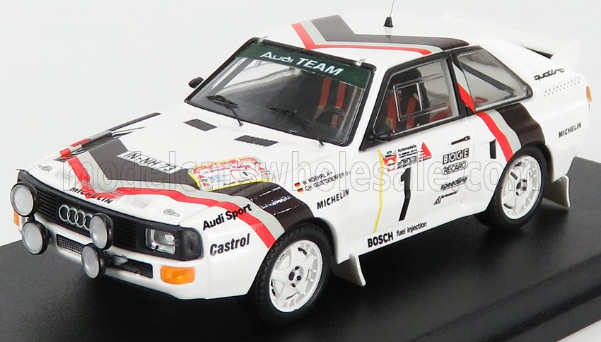 Maquette réduite d'une voiture de rallye Audi Sport blanche avec bandes rouges et noires, disponible sur Vroomi.