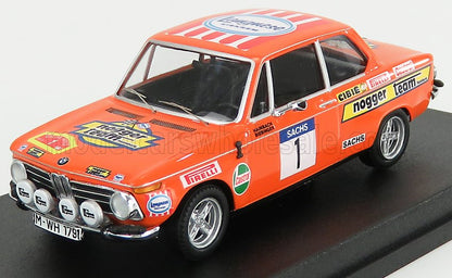 Modèle réduit vintage d'une BMW orange de rallye avec autocollants des sponsors, phares et numéro de course, disponible sur Vroomi.