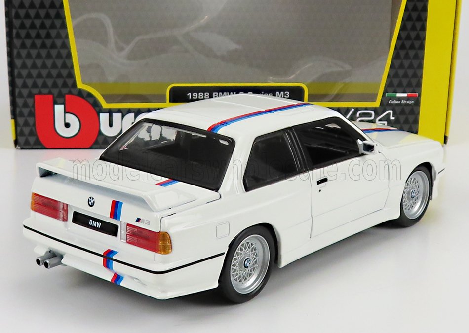 Modèle réduit BMW M3 blanc de 1988 avec bandes bleues et rouges et aileron arrière, disponible sur Vroomi.