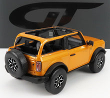 Modèle réduit orange à toit ouvert de véhicule tout-terrain avec roue de secours à l'arrière, jantes détaillées, disponible chez Vroomi.