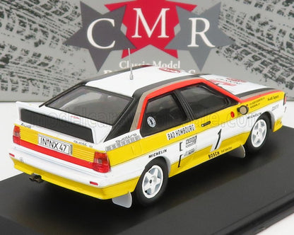 Modèle réduit Audi Quattro de rallye blanc et jaune avec décalcomanies de course, présenté sur la plateforme Vroomi.