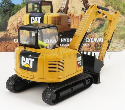 Mini-pelle hydraulique CAT 308E2 jaune avec chenilles noires, présentée avec une affiche en arrière-plan, disponible sur Vroomi.