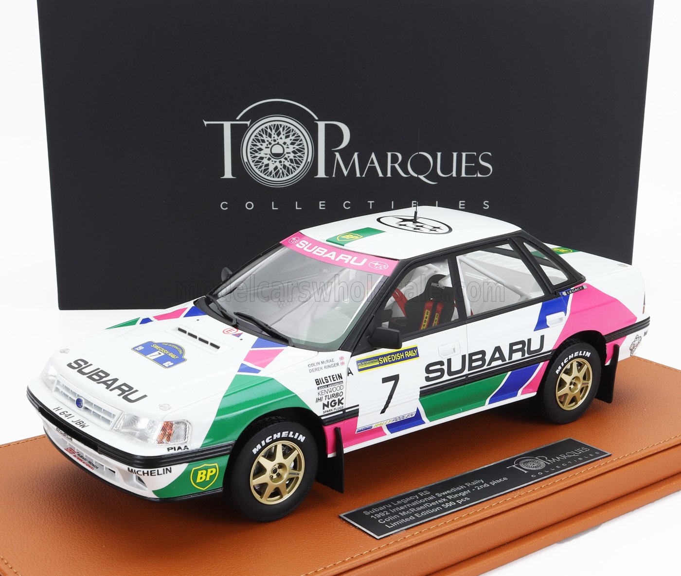 Modèle réduit de voiture de rallye Subaru Legacy RS à l'échelle 1:18 sur socle d'exposition dans un coffret Top Marques Collectibles, disponible sur Vroomi.