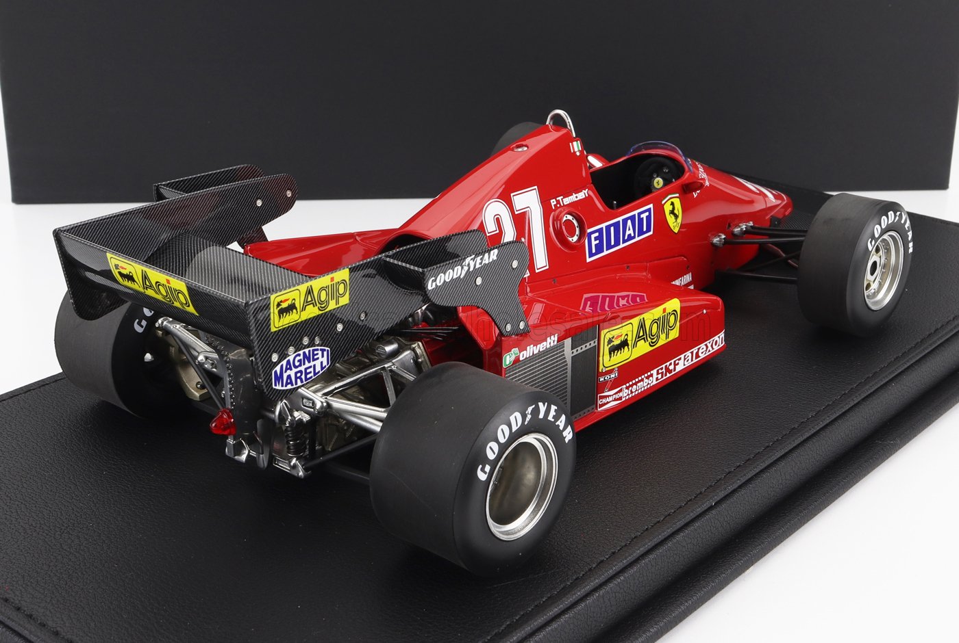 Modèle réduit vintage d'une Ferrari de Formule 1 rouge avec pneus Goodyear et logos Agip, présenté sur Vroomi.