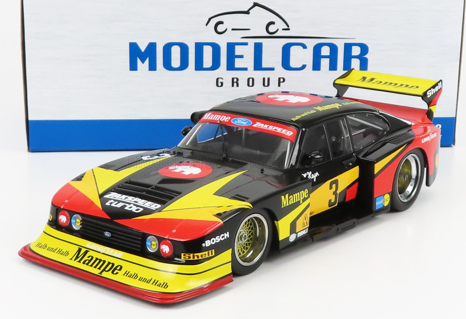 Voiture de course Ford Zakspeed Turbo noire, rouge et jaune avec le logo Mampe et un grand aileron arrière, disponible chez Vroomi.