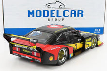 Modèle réduit de voiture de course Porsche à l'échelle 1:18, noir, rouge et jaune, avec logos Mampe et Shell, disponible chez Vroomi.