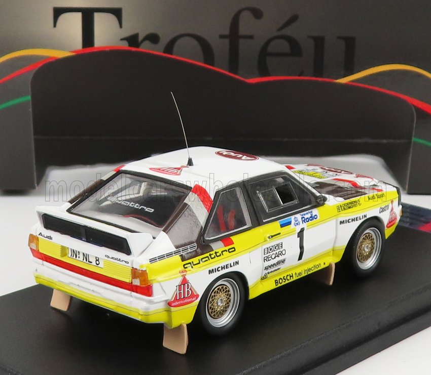 Modèle réduit de voiture de rallye Audi Quattro blanche et jaune avec décalcomanies de course, présenté sur Vroomi.