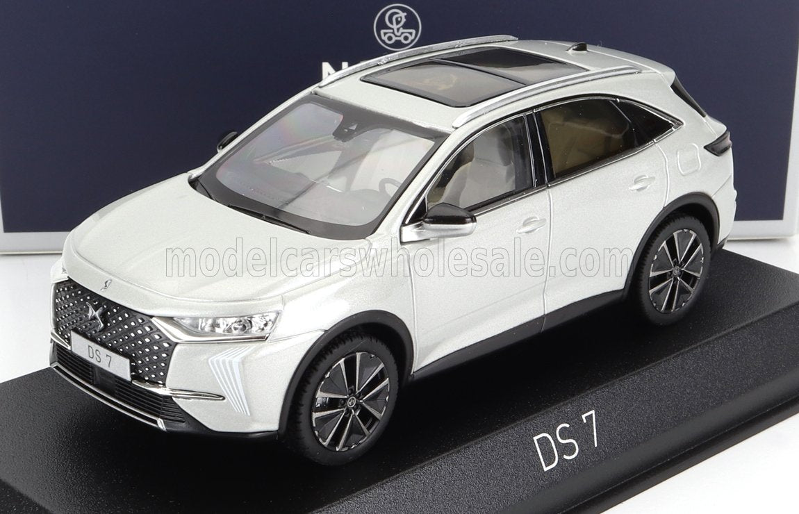 Modèle réduit de voiture DS 7 blanche sur socle noir avec étiquette DS 7, désormais disponible sur la plateforme Vroomi.