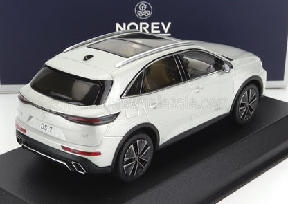 Modèle SUV DS 7 blanc sur socle noir avec logo Norev en arrière-plan, disponible sur la plateforme Vroomi.