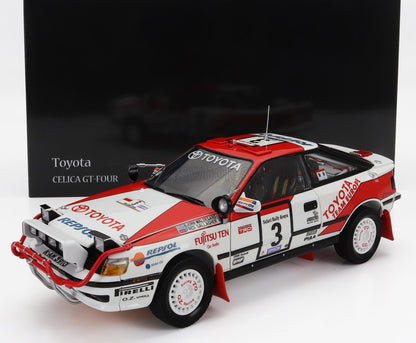 Modèle réduit de la voiture de rallye Toyota Celica GT-Four rouge et blanche avec autocollants des sponsors, présenté dans un coffret noir griffé, disponible sur Vroomi.
