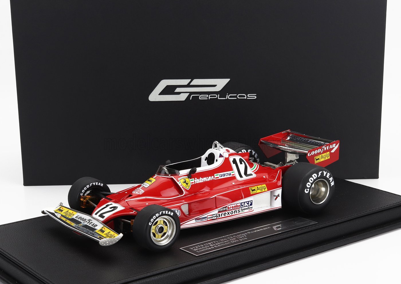 Réplique miniature de la Ferrari F1 312T2 rouge sur socle d'exposition avec pneus Goodyear, édition limitée, disponible sur Vroomi.