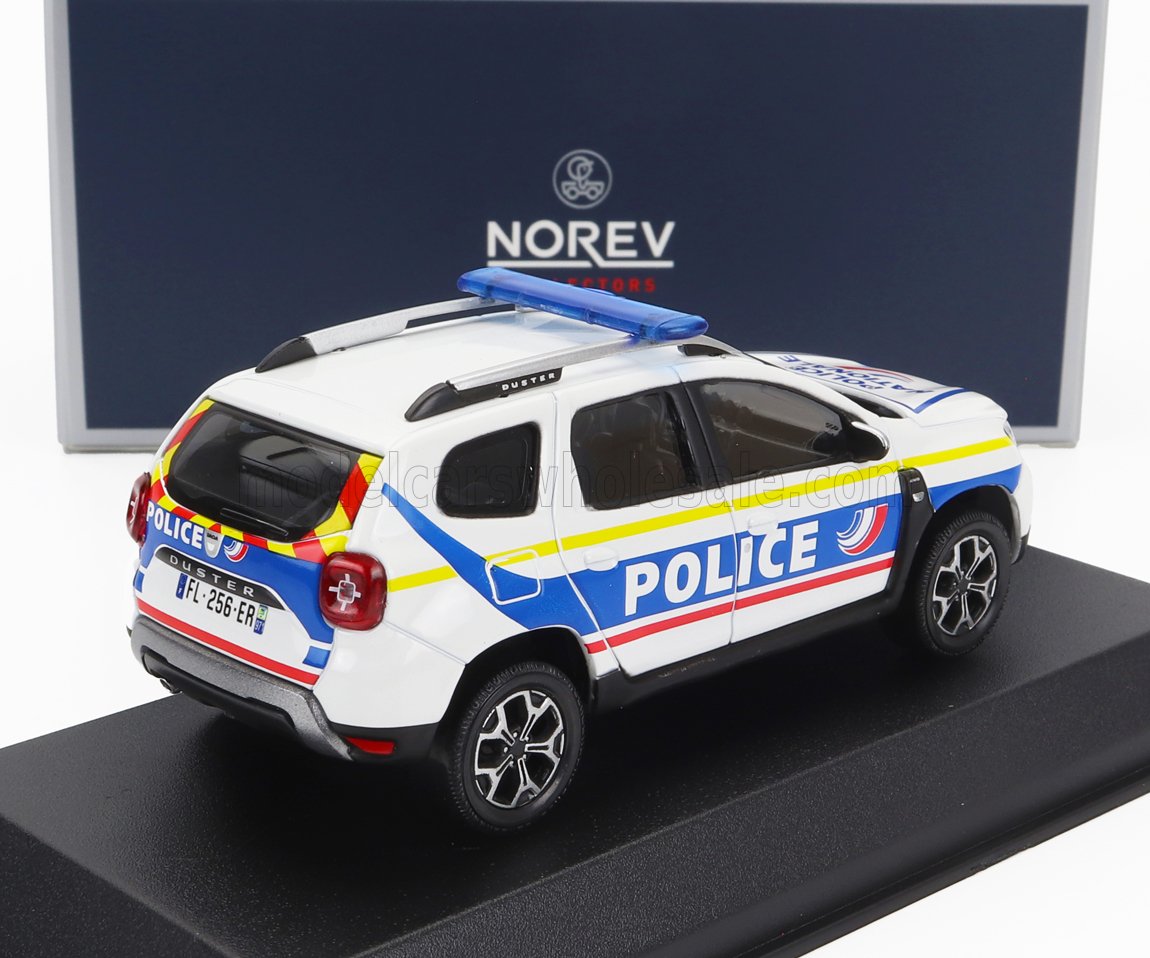 Modèle réduit de voiture de police Dacia Duster Norev blanc avec marquages bleus et jaunes, sur socle d'exposition, disponible sur Vroomi.