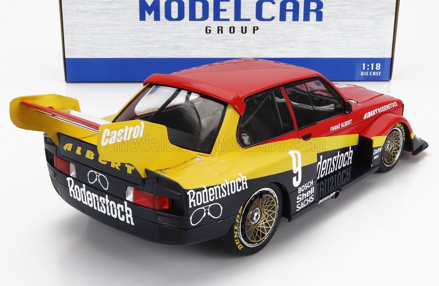 Modèle réduit de voiture de course Porsche 944 à l'échelle 1:18, de couleur jaune, rouge et noir, avec les logos Rodenstock et Castrol, disponible chez Vroomi.