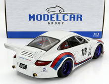 Modèle réduit de voiture de course Porsche 997 à l'échelle 1:18, blanc avec bandes bleues et rouges, roues violettes et grand aileron arrière, disponible chez Vroomi.
