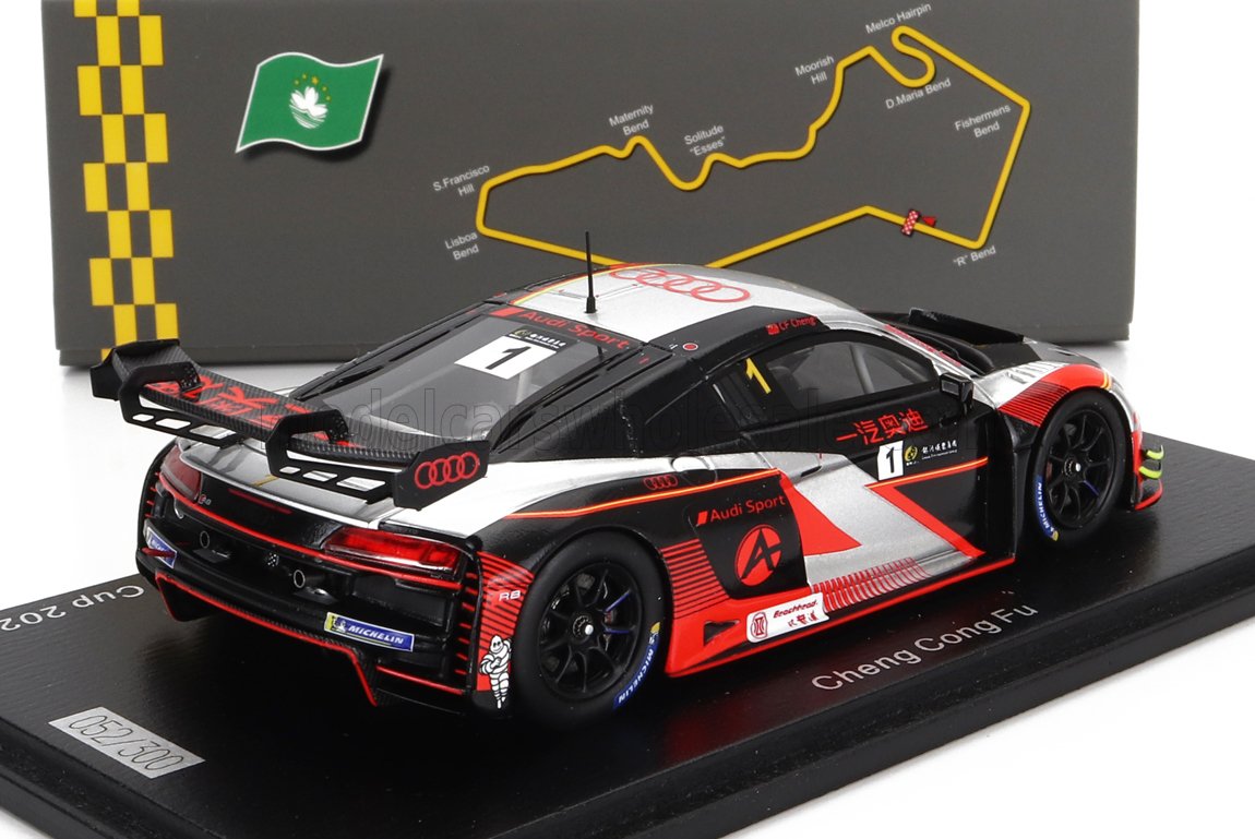 Modèle réduit de voiture de course Audi R8 GT3 avec livrée noire et rouge, numéro 1, présenté sur un socle avec le circuit de Macao en arrière-plan, proposé sur Vroomi.