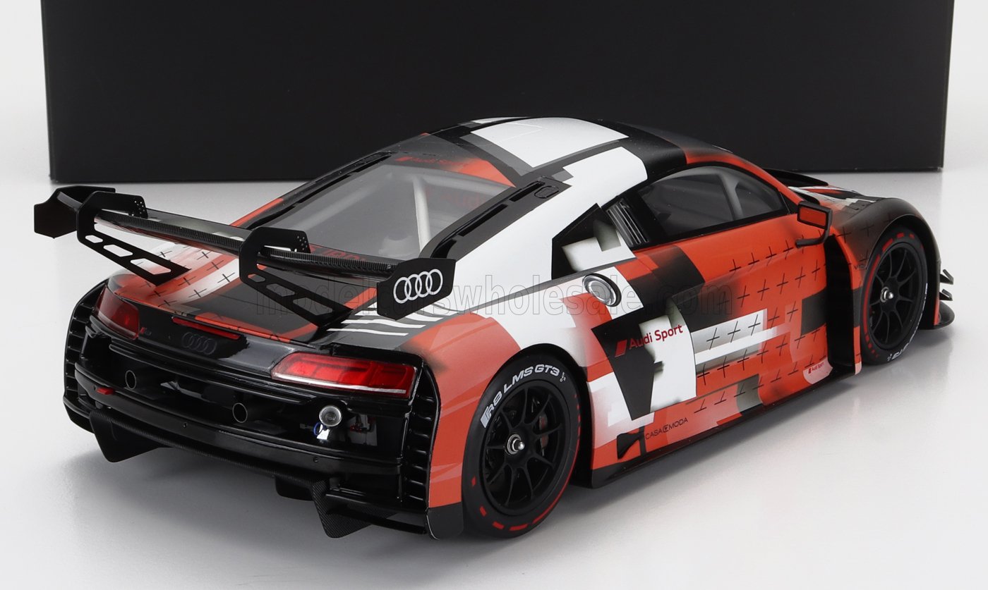 Vue arrière et latérale du modèle réduit de voiture de course Audi Sport avec livrée noire, blanche et orange, disponible sur la plateforme Vroomi.