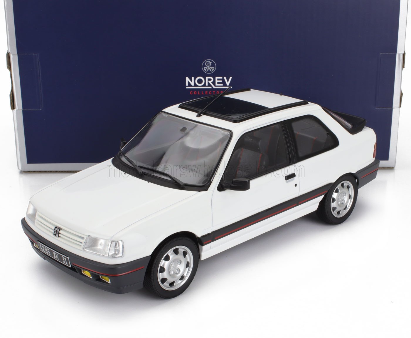 Modèle réduit Peugeot 309 GTI blanc avec détails noirs et rouges, présenté dans un coffret collector Norev, disponible sur Vroomi.