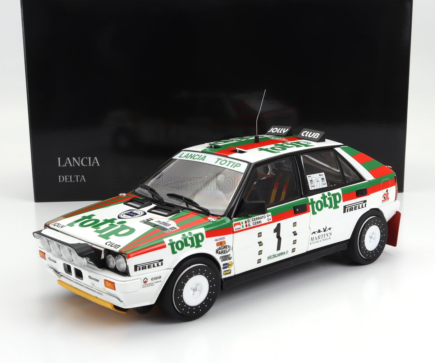 Modèle réduit de voiture de rallye Lancia Delta aux couleurs de Totip, présenté avec une boîte Lancia Delta noire, disponible sur Vroomi.