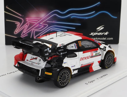 Maquette réduite de la voiture de rallye Toyota Gazoo Racing avec le logo Denso, décalcomanies détaillées, présentée sur un fond aux couleurs de la marque, disponible sur Vroomi.