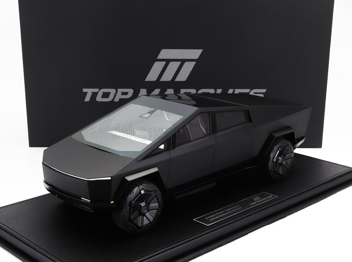 Modèle Cybertruck noir mat sur socle d'exposition avec logo Top Marques, disponible chez Vroomi.