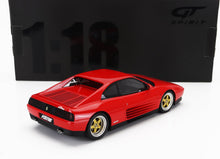 Modèle réduit de voiture Koenig Ferrari à l'échelle 1:18 avec jantes dorées devant la boîte noire GT Spirit, disponible chez Vroomi.