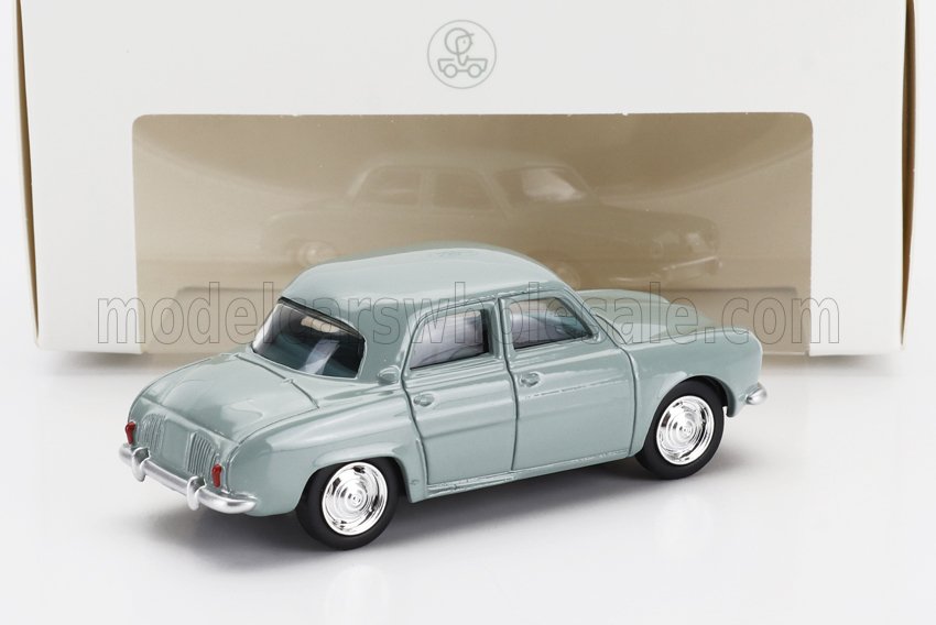 Modèle réduit vintage gris avec roues chromées exposé devant une boîte blanche, accessible sur Vroomi.