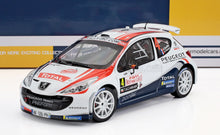 Modèle réduit à l'échelle 1/18 de la Peugeot 207 S2000 de rallye avec livrée Monte Carlo 2011, disponible chez Vroomi.