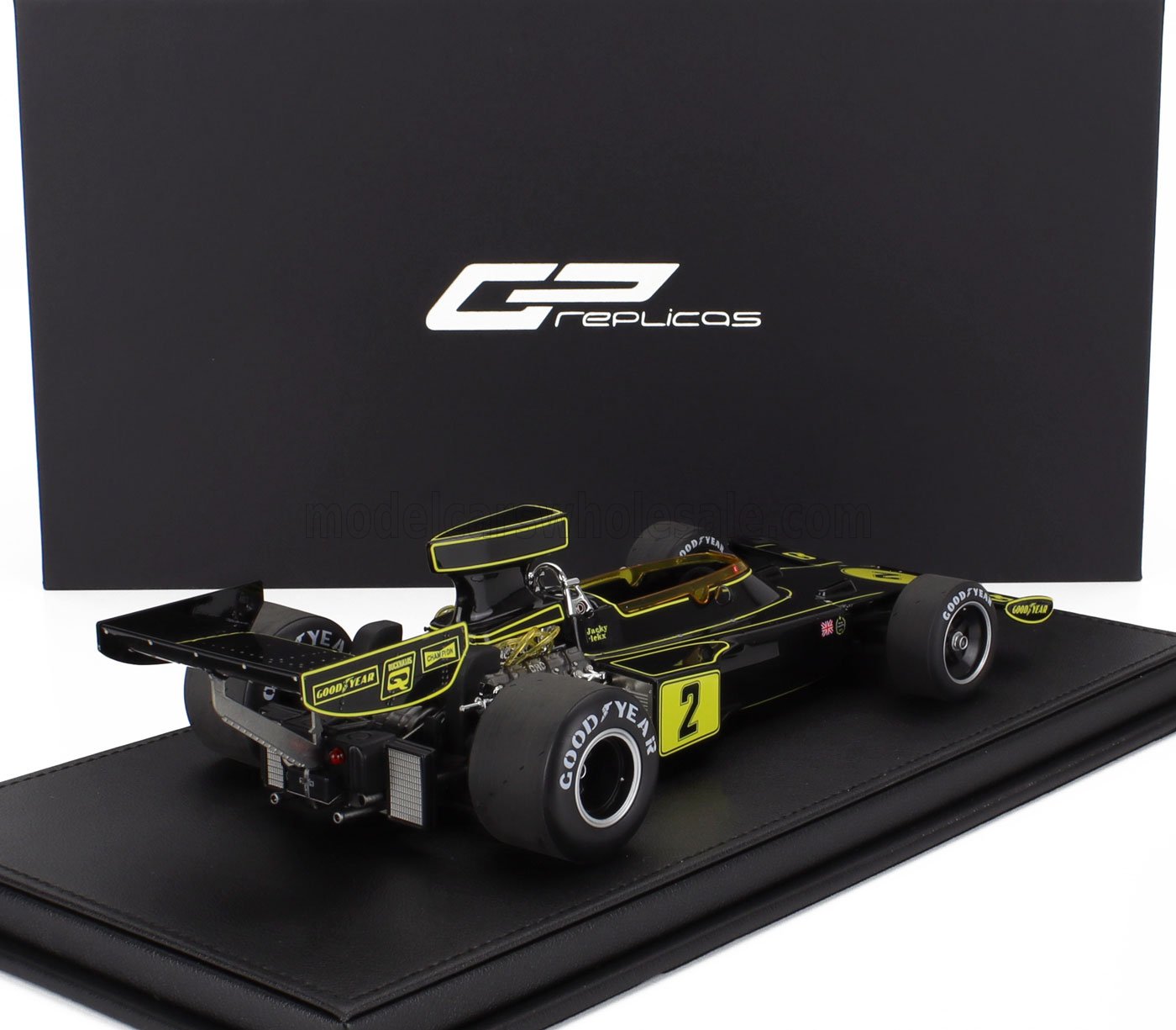 Modèle réduit vintage noir de Formule 1 avec contours jaunes et pneus Goodyear sur socle d'exposition, proposé sur Vroomi.