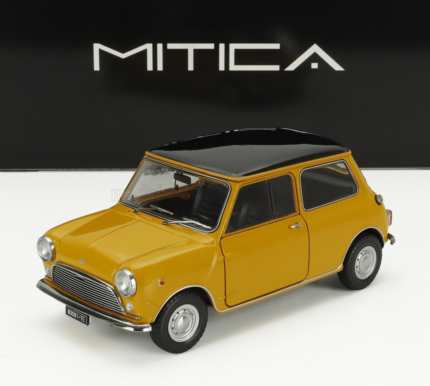 Modèle réduit de Mini Cooper classique jaune avec toit noir présenté sur fond MITICA, disponible sur Vroomi.