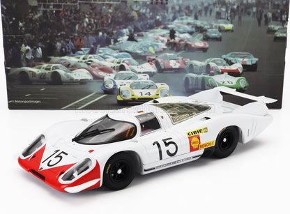 Modèle réduit de voiture de course Porsche blanche et rouge numéro 15 avec roues noires, présenté avec une photo vintage de la course du Mans, disponible sur Vroomi.