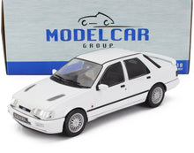 Modèle réduit de voiture Ford Sierra RS Cosworth à l'échelle 1:18, blanc, avec roues détaillées, présenté devant un emballage Model Car Group, disponible chez Vroomi.