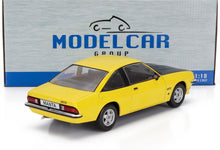 Modèle réduit Opel Manta GT/E jaune à l'échelle 1:18 avec capot noir, présenté dans un emballage Model Car Group, disponible chez Vroomi.