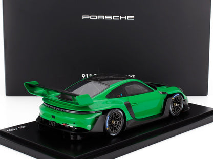Modèle réduit vert Porsche 911 GT3 RS sur une plateforme d'exposition avec un fond noir Porsche, également sur Vroomi.