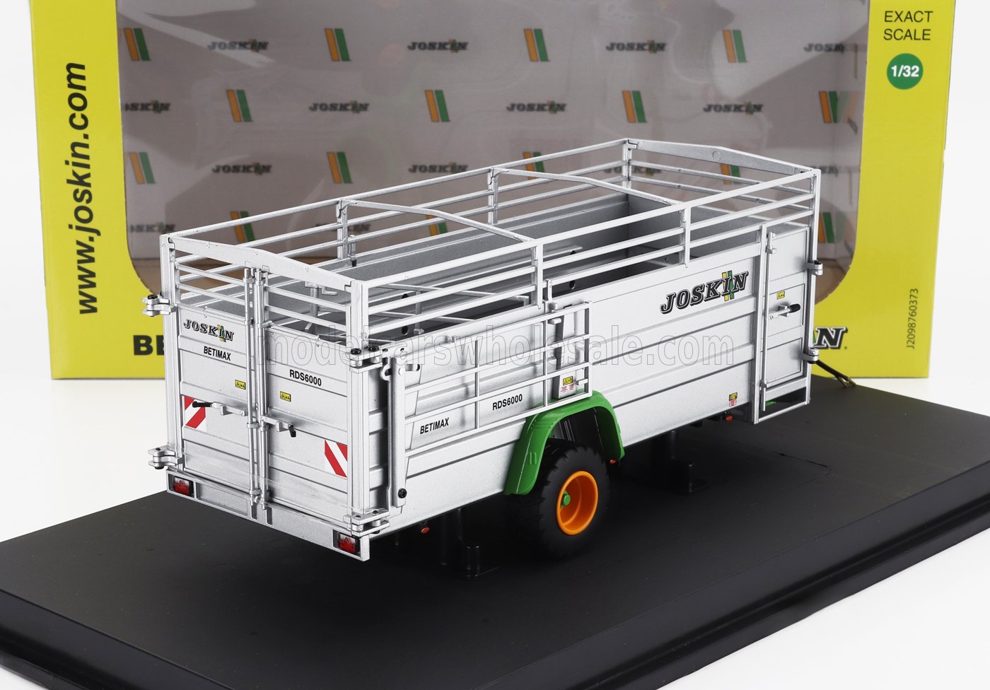 Modèle réduit à l'échelle 1/32 de la remorque à bétail Joskin Betimax RDS6000 avec carrosserie argentée, roues vertes et orange, présenté sur un socle noir, disponible chez Vroomi.