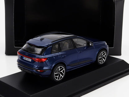 Modèle réduit Audi Q6 bleu sur socle noir avec fond en carton, également proposé sur Vroomi.