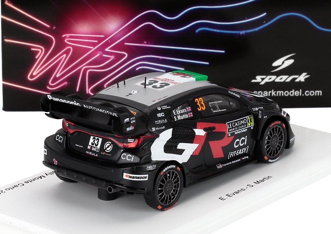 Modèle réduit de voiture de rallye Toyota GR à l'échelle 1/43, noir et gris, avec le numéro 33 et les autocollants des sponsors, présenté sur un socle blanc, disponible chez Vroomi.