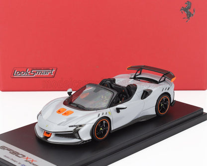 Modèle réduit Ferrari SF90 XX argenté avec détails orange sur socle noir, vendu par Vroomi.