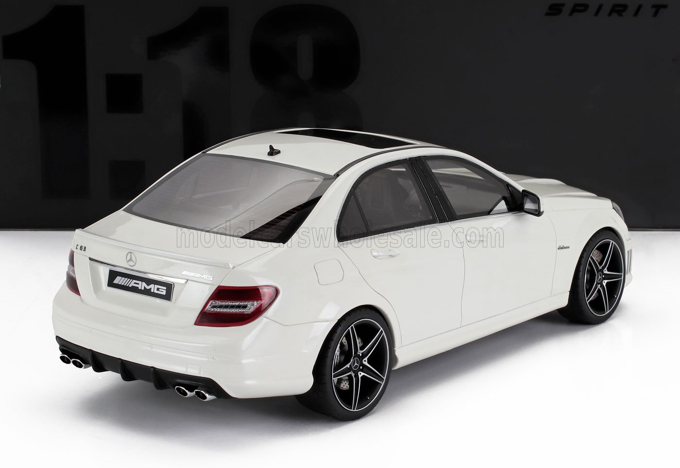 Modèle réduit Mercedes-Benz C63 AMG blanc avec jantes noires et quatre pots d'échappement, disponible chez Vroomi.