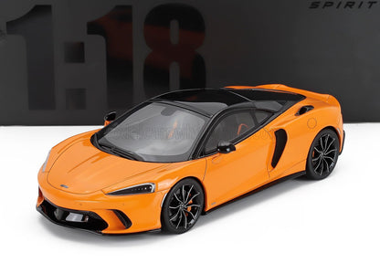 Modèle réduit McLaren GT orange et noir à l'échelle 1:18 sur fond blanc, objet de collection disponible chez Vroomi.