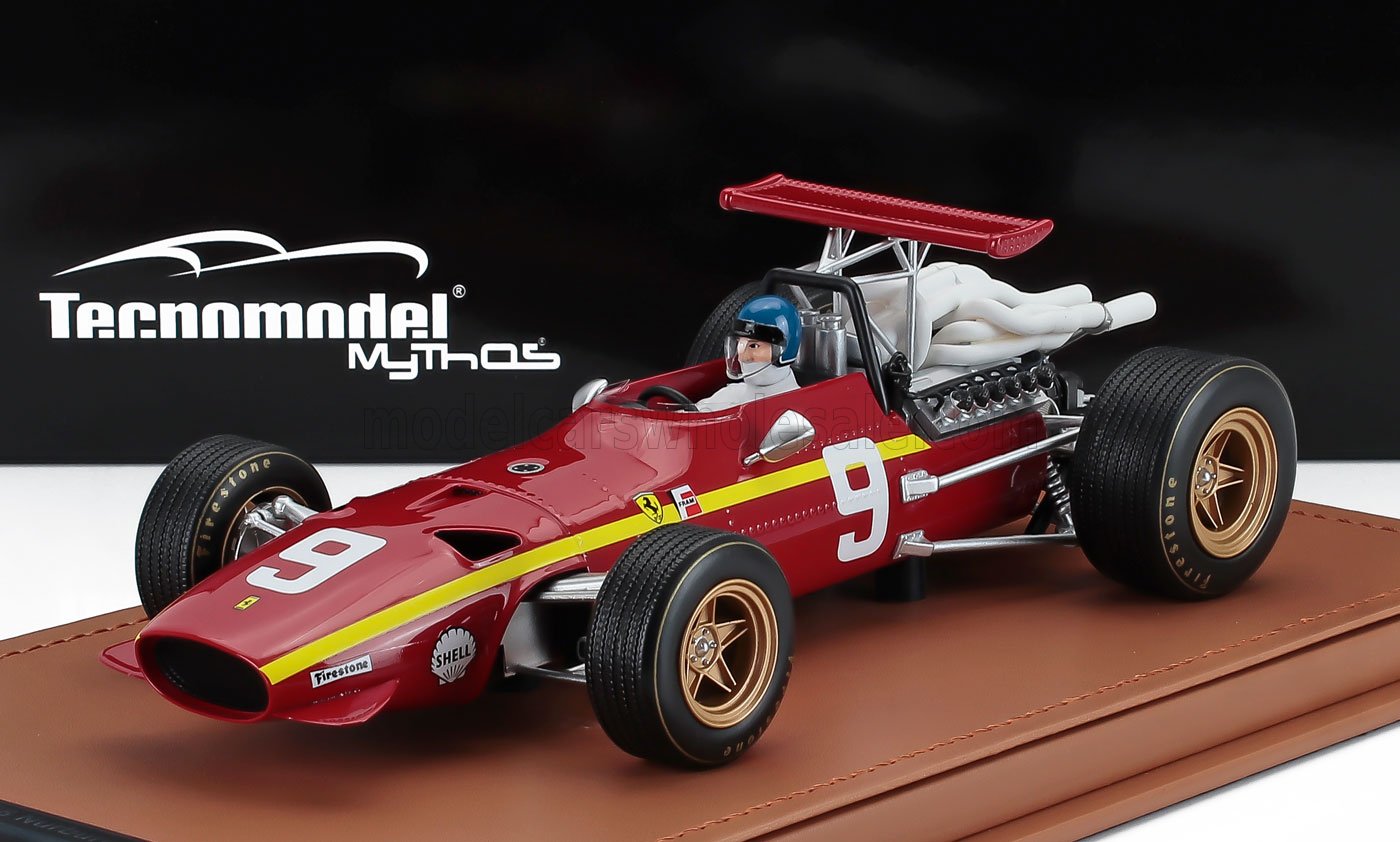 Modèle réduit vintage d'une Ferrari de course rouge avec le numéro 9, figurine du pilote, sur socle d'exposition, proposé sur Vroomi.