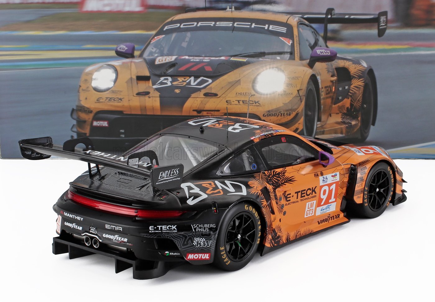 Modèle réduit de voiture de course Porsche 911 GT3 avec livrée noire et orange, graphismes représentant des palmiers et autocollants des sponsors, présenté sur Vroomi.