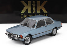 Modèle réduit à l'échelle 1/18 d'une berline BMW 323i bleu clair avec des détails réalistes, disponible chez Vroomi.